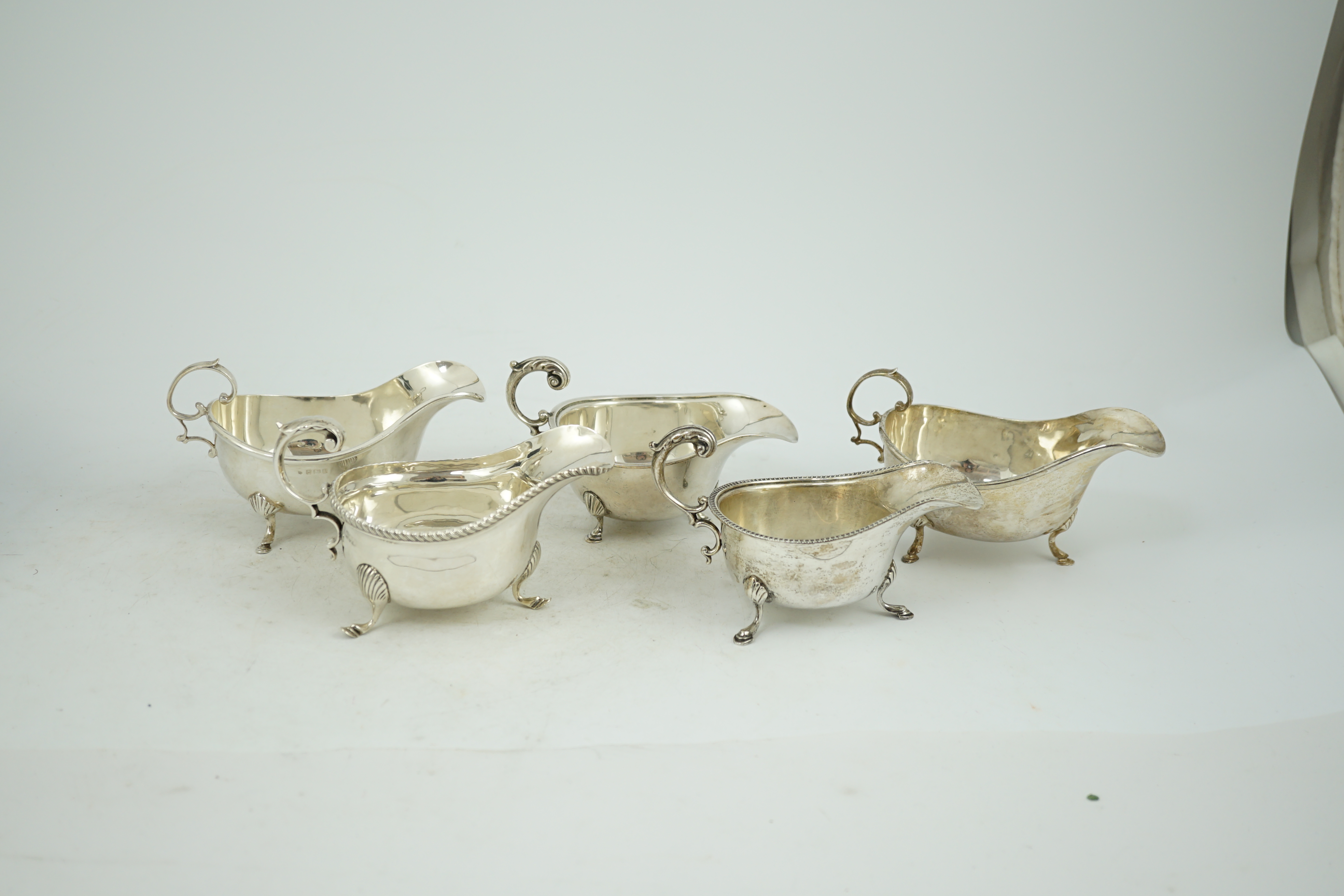 Five assorted early 20th century and later silver sauce boats, various dates and makers, 21.3oz.